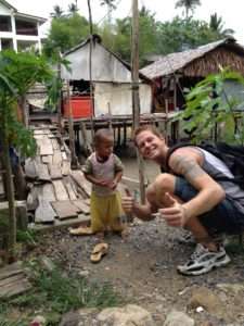 Derek posing with child while sourcing kratom in Indonesia