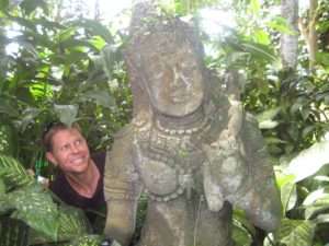 Derek posing with statue in jungle