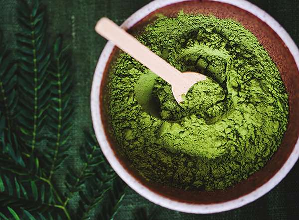 Kratom Powder in Bowl With Wooden Spoon
